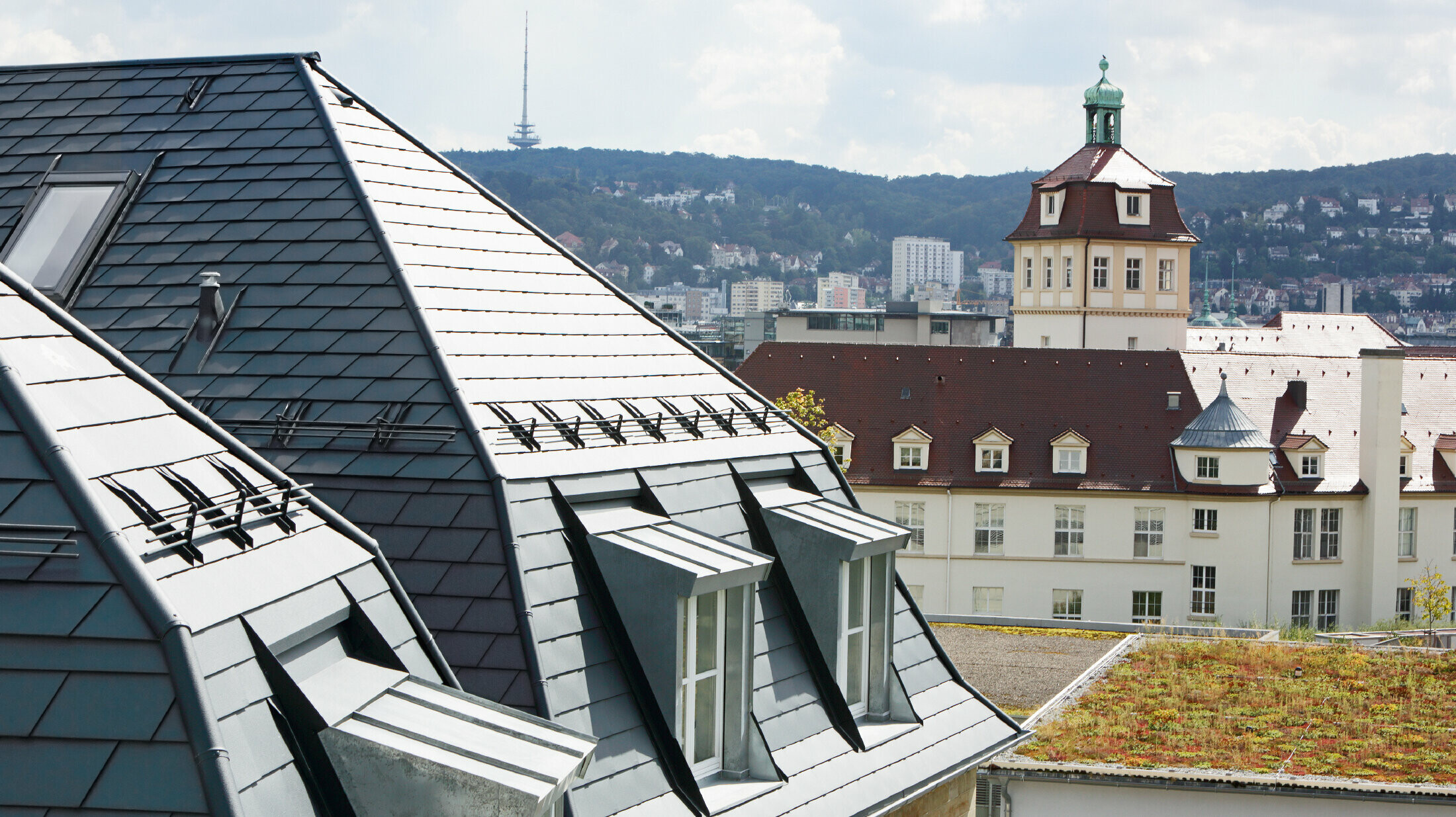 Altes Stadthaus in Stuttgart mit geknicktem Dach und vielen Gaubenfenstern, eingedeckt mit der Aluschindel von PREFA in P.10 Anthrazit
