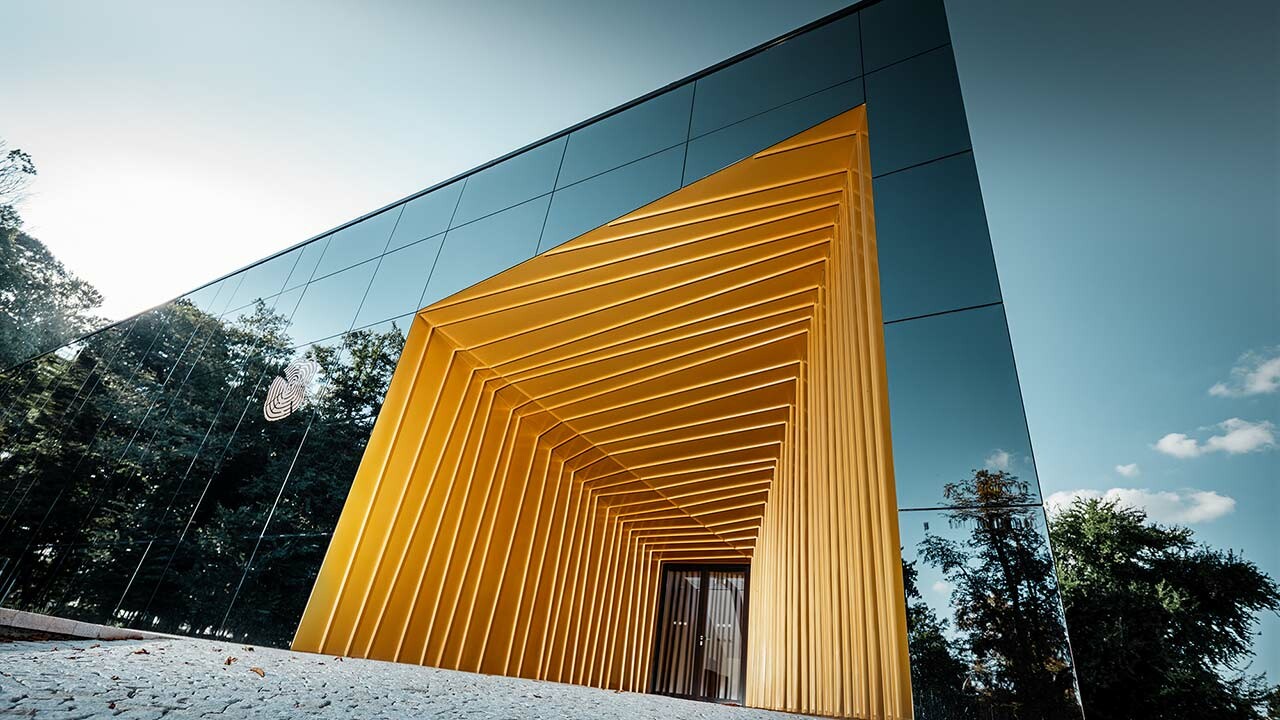 Château Rúbaň wagt die Sanierung mit Aluminium in gold und spiegelnden Fassadenflächen als modernen Zubau