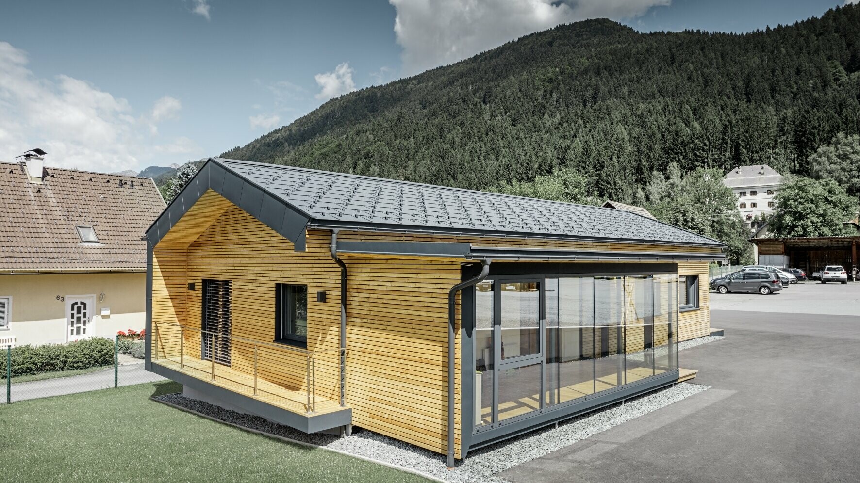 Neues Bürohaus der Firma Holzbau Faltheiner mit Lärchenholz-Fassade und einem PREFA Dach in anthrazit und großen Glasflächen, das Satteldach hat kaum Dachvorsprung und wirkt sehr modern