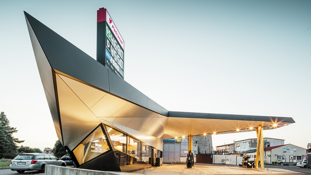 Seitlicher Blick auf die dynamische, mit Aluminium bekleidete Tankstelle von Architekt Daniel Zerzán: Etliche Dreiecke und Trapeze strukturieren die Fassade.