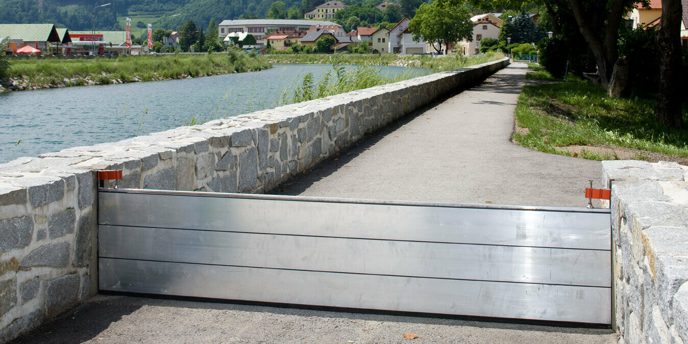 Aufgebauter PREFA Hochwasserschutz neben einem Fluss