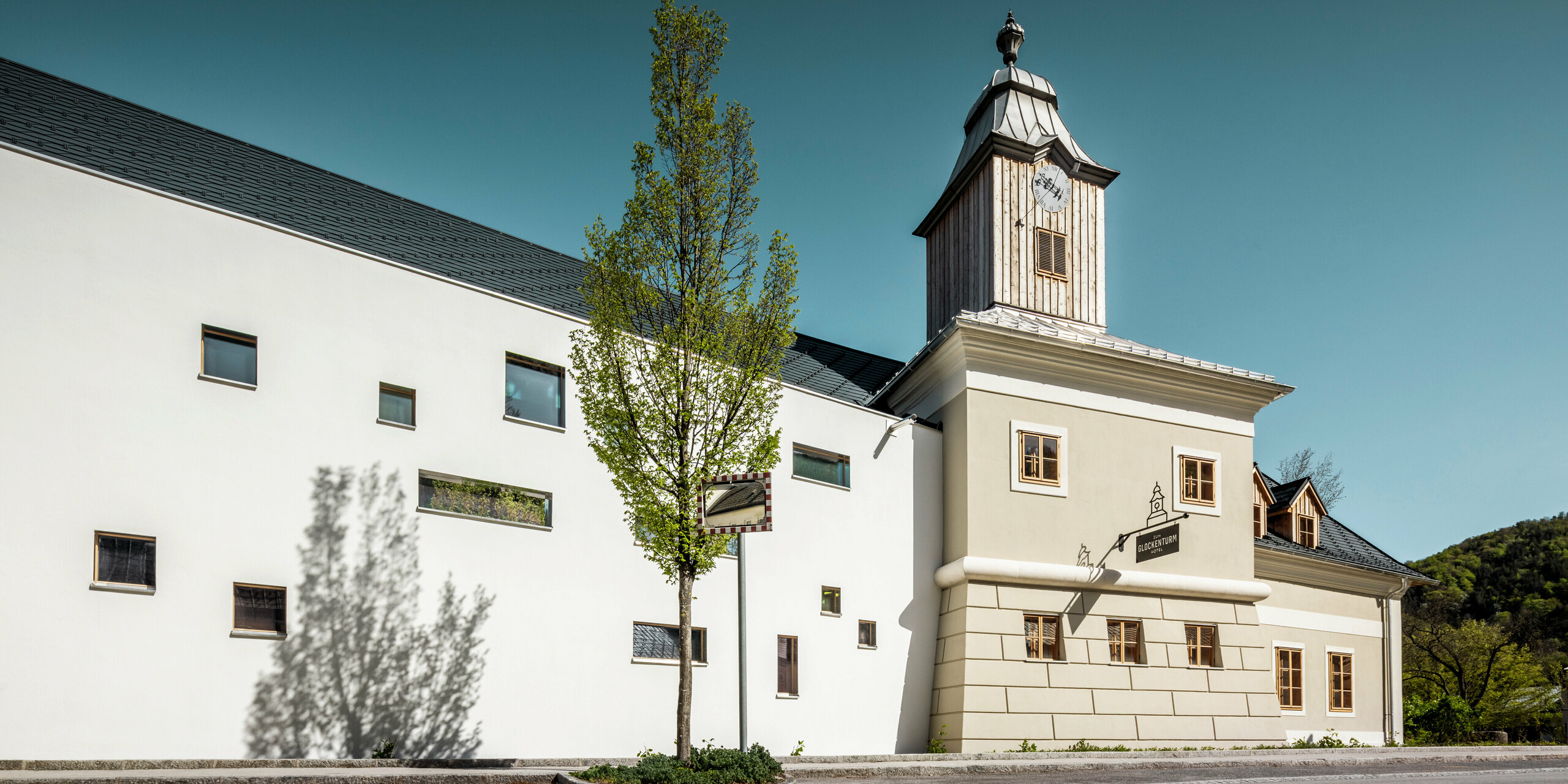 Das Dach des Hotels Glockenturm in Marktl bei Lilienfeld wurde mit der PREFA Dachschindel in P.10 Anthrazit verkleidet. Das PREFA Dachentwässerungssystem des Gebäudes ist in Naturblank gehalten. Unweit vom Hotel Glockenturm liegt das Leopold - unser Wirtshaus. Das Restaurantgebäude wurde ebenfalls mit PREFA Produkten eingedeckt.