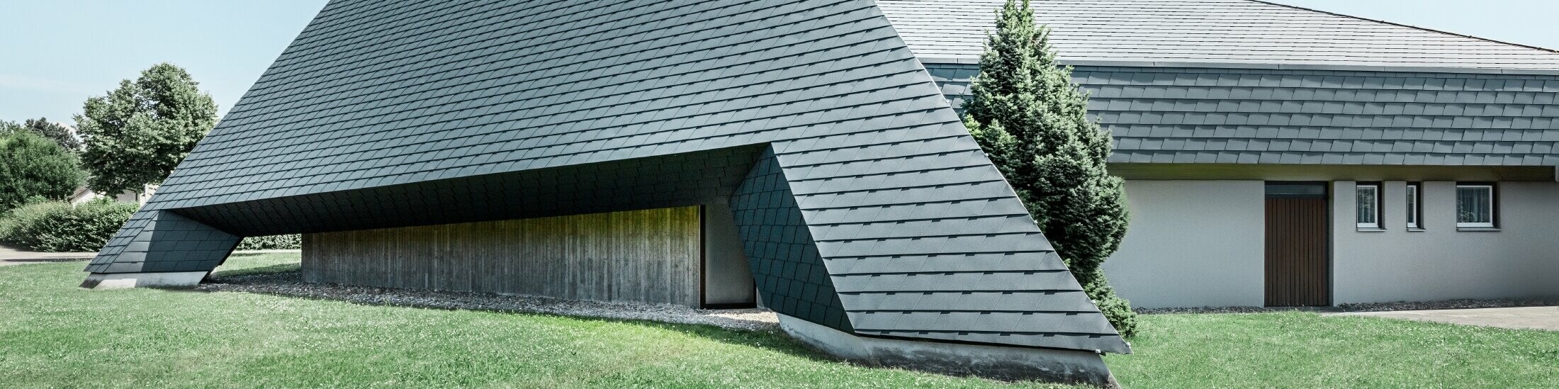 katholische Kirche in Langenau mit einem Design ähnlich einer Pyramide eingedeckt mit PREFA Aluminiumschindeln in anthrazit