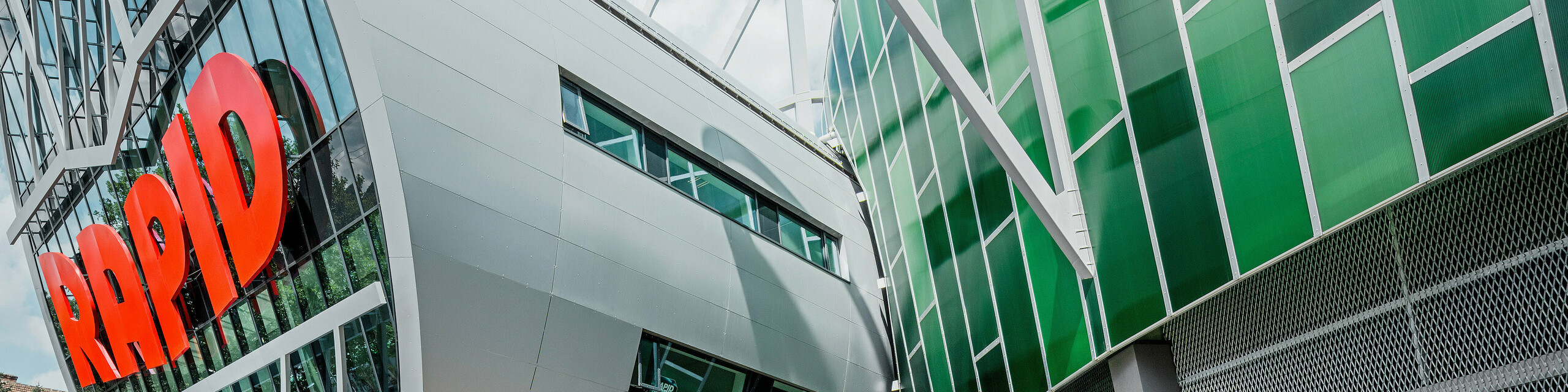 Das Allianz Stadion des SK Rapid Wien, gekennzeichnet durch eine imposante Röhre im Eingangsbereich. Die Röhre misst einen Durchmesser von 20 Meter. Die spektakuläre Fassade der Röhre ist mit PREFA Aluminium Verbundplatten in Silbermetallic verkleidet. Die Aluminiumhülle verleiht der Struktur ein futuristisches Design, das Technologie und Sportgeist in harmonischer Architektur vereint.