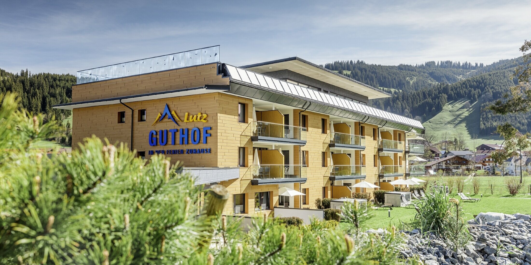 Der Guthof Lutz, umgeben von viel Natur, wurde mit den PREFA Sidings in Eiche natur verkleidet. Auf der Fassade erkennt man auch das Logo der Ferienwohnungen.