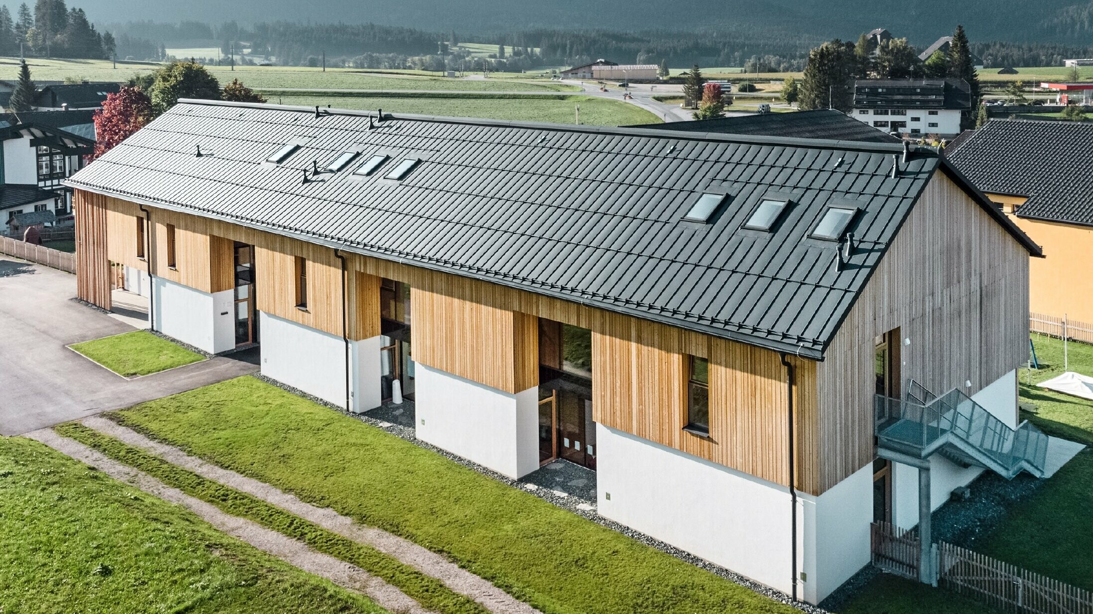 Kräuterkindergarten in Bad Mitterndorf mit großem PREFALZ Dach in P.10 Anthrazit und Holzfassade