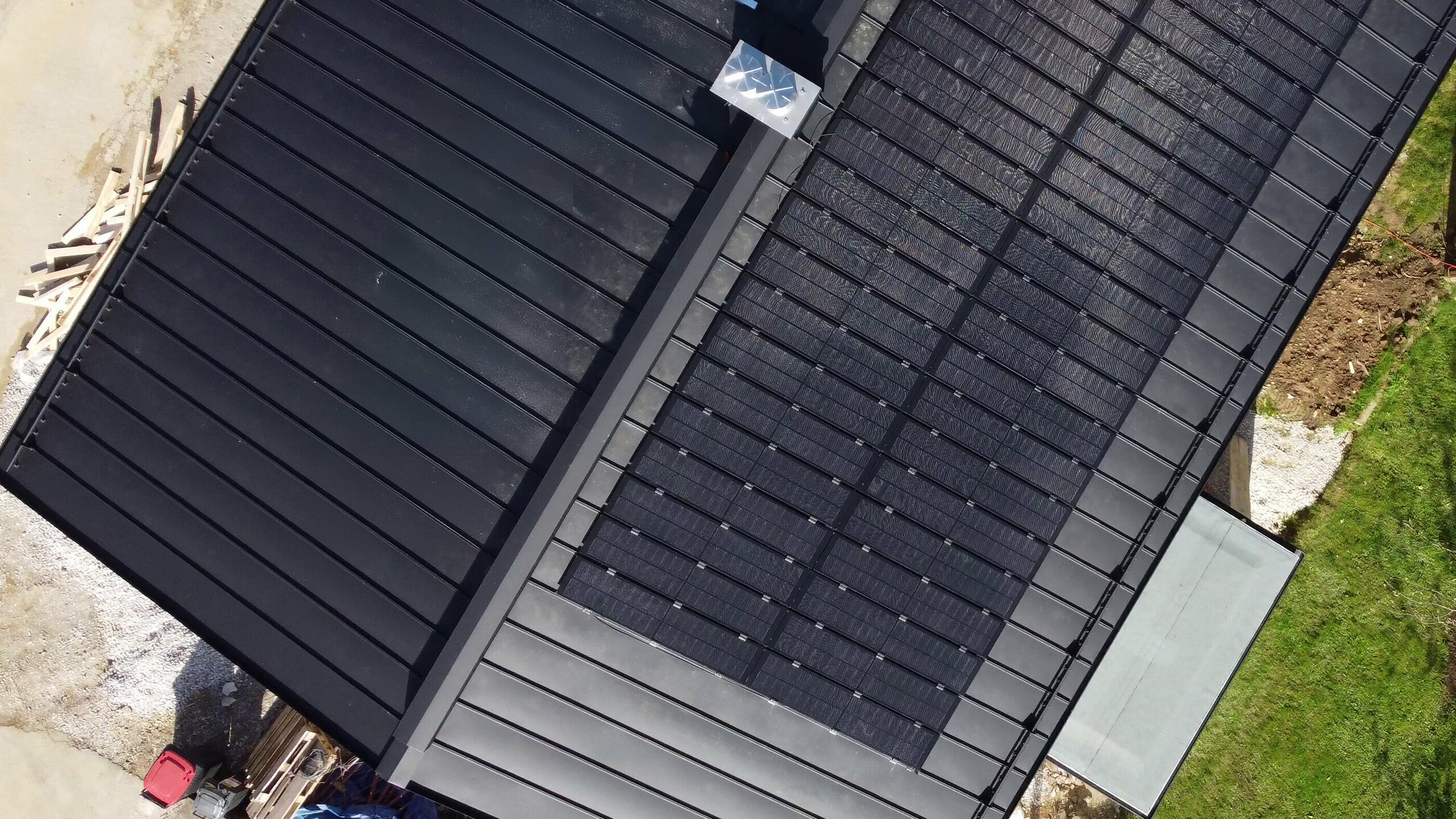 Draufsicht auf ein PREFALZ-Dach mit montierten Solarmodulen, das die Integration von Glas/Glas-PV-Modulen und unbedeckten Dachflächen zeigt.