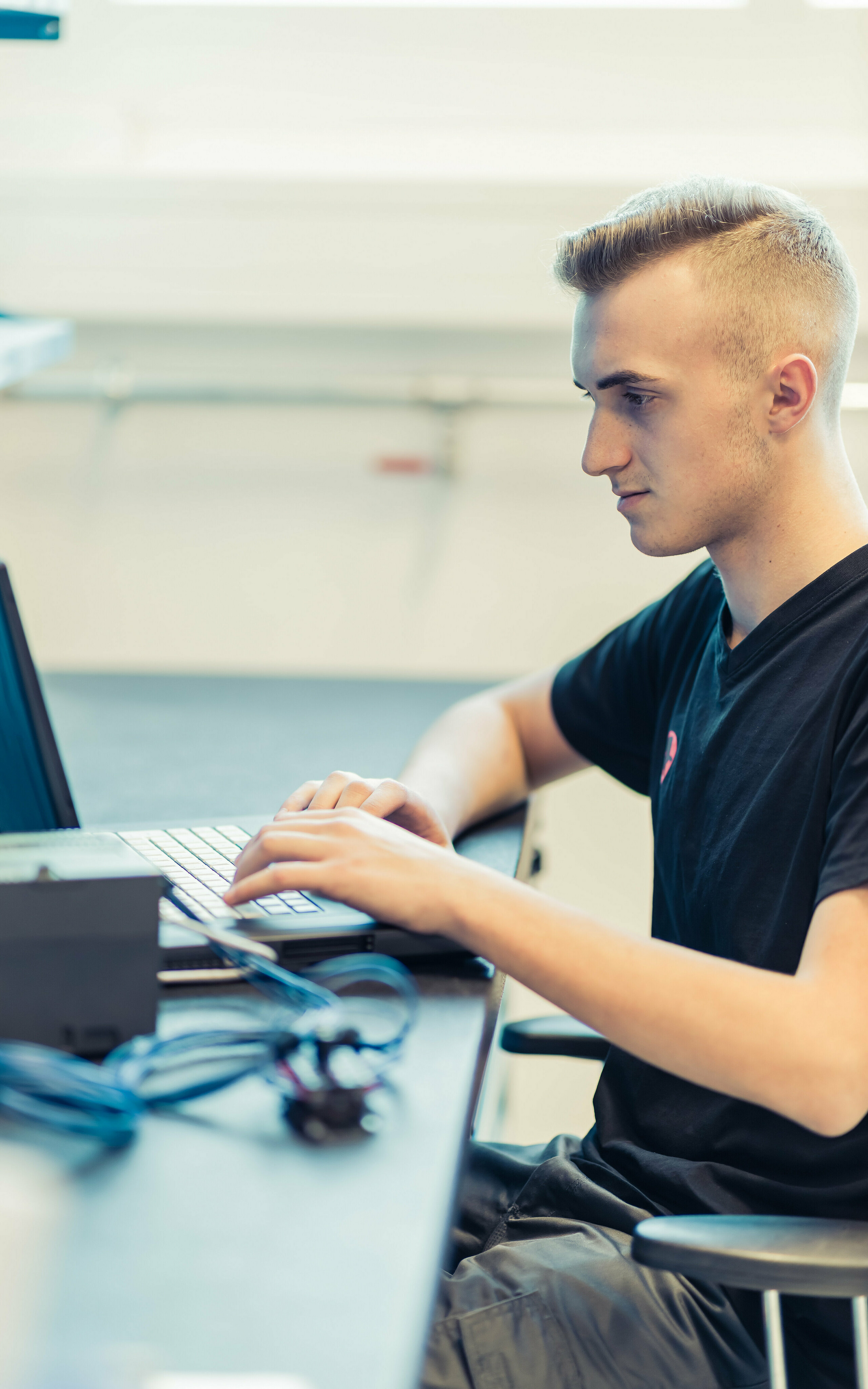 PREFA Lehrling für technischer Zeichner sitzt vor dem Laptop.