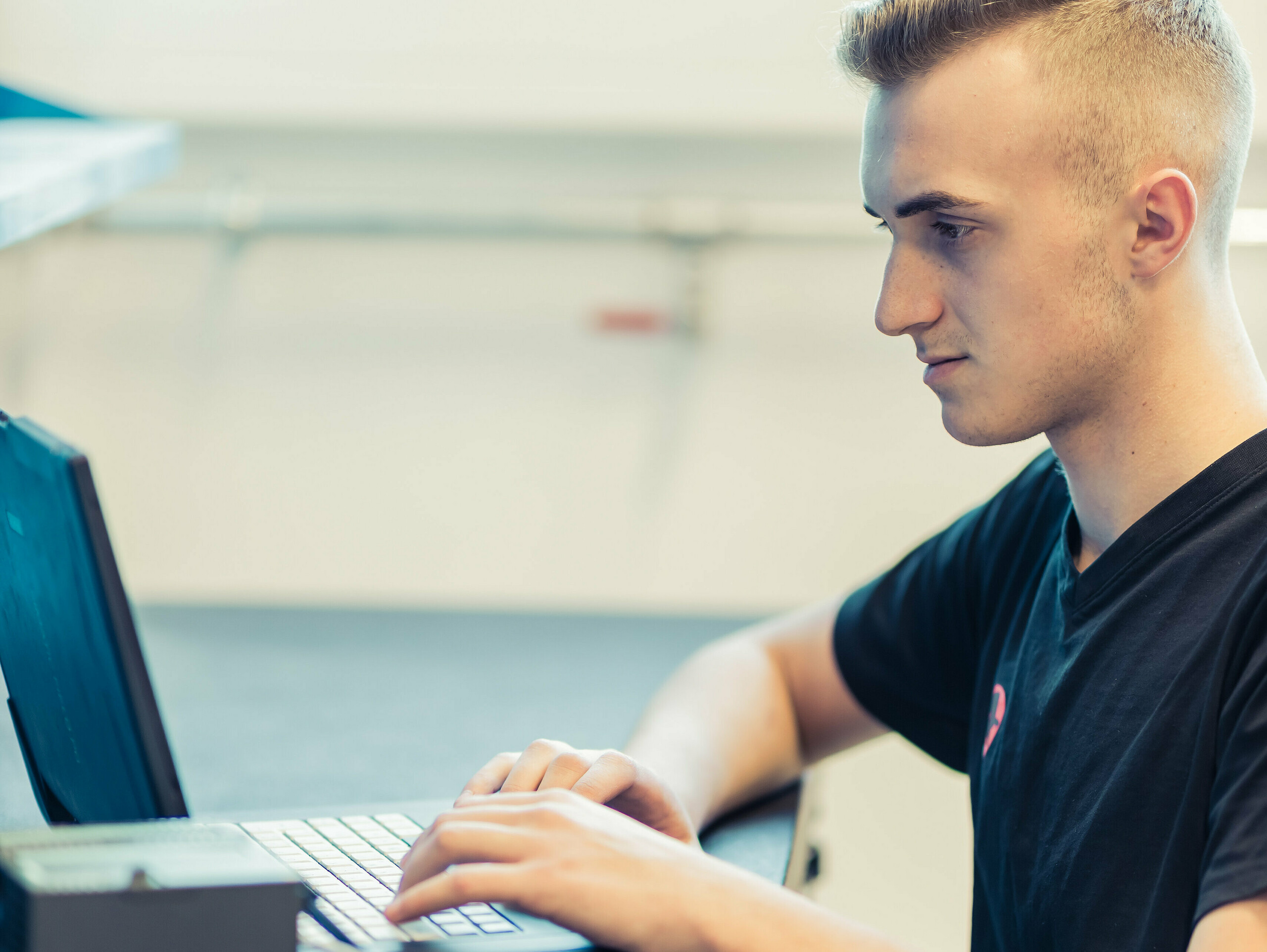 PREFA Lehrling für technischer Zeichner sitzt vor dem Laptop.