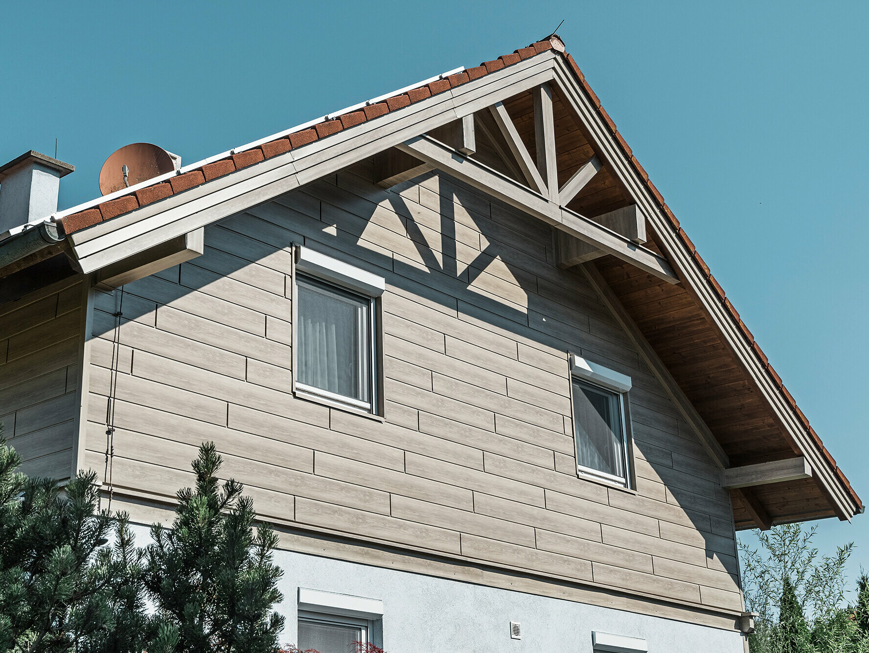 Einfamilienhaus in Landegg aus PREFA Sidings in Beige und Grau. Die verschiedenen Farbtöne der Sidings zeigen die Flexibilität bei der Farbgestaltung und verleihen dem Gebäude eine moderne und stilvolle Optik.