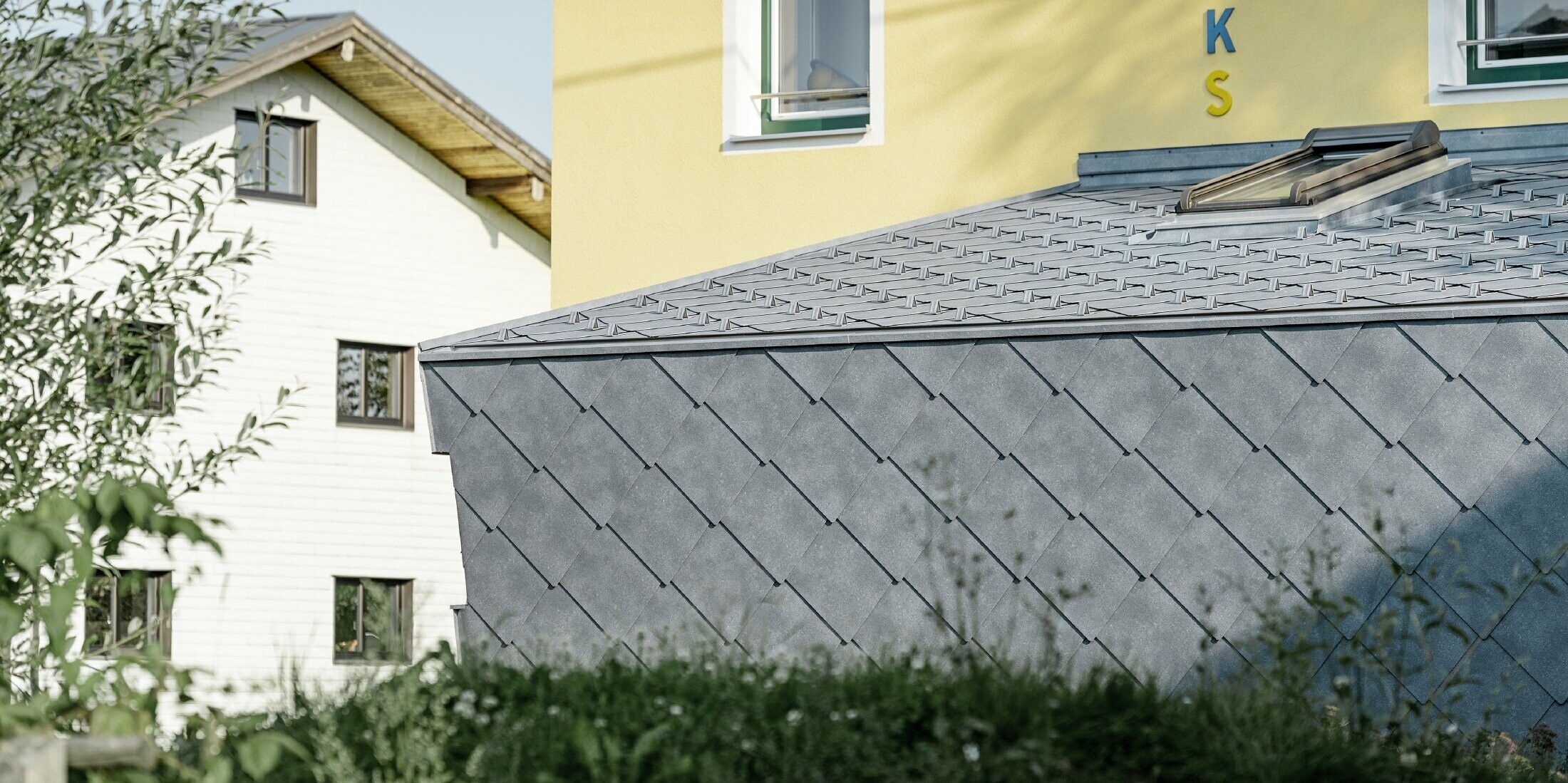 Zubau einer Volksschule eingedeckt mit der Dach- und Wandraute aus Aluminium von PREFA in steingrau