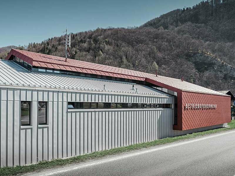 moderne Betriebsfeuerwehr der Firma Neuman mit gleichmäßigen Blechbahnen in silbermetallic und rotem Aludach und Alufassade mit der Wandraute von PREFA