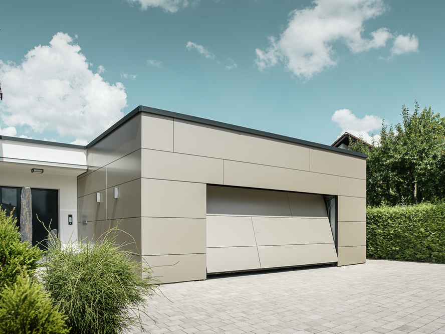 Modernes Gebäude mit PREFA Aluminium Verbundplatten in der Farbe Bronze. Die präzise und geradlinige Fassadengestaltung verleiht der Garage und dem Anbau einen hochwertigen, zeitlosen Look mit edlem Schimmer.