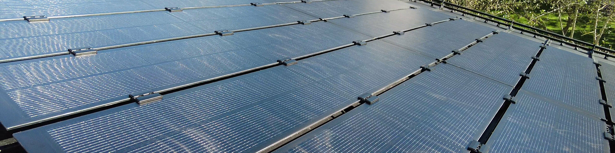 Ansicht eines mit PREFALZ Solarmodulen ausgestatteten Dachs, mit Glas/Glas PV-Modulen, die präzise an die Falzbreiten der Doppelstehfalzbahnen angepasst sind.