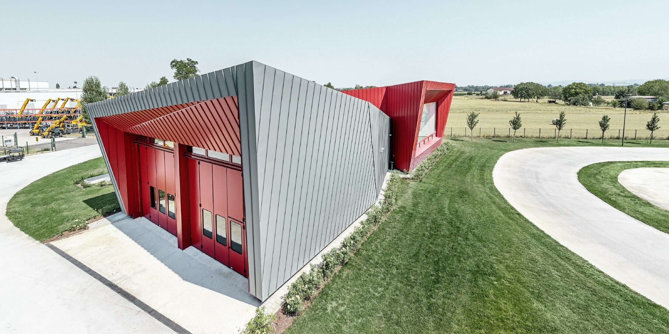 modernes Trainingscenter von Dieci in Montecchio Emilia ,Italien, mit Tribüne mit Aluminiumfassade mit Prefalz in hellgrau und Falzonal in karminrot 