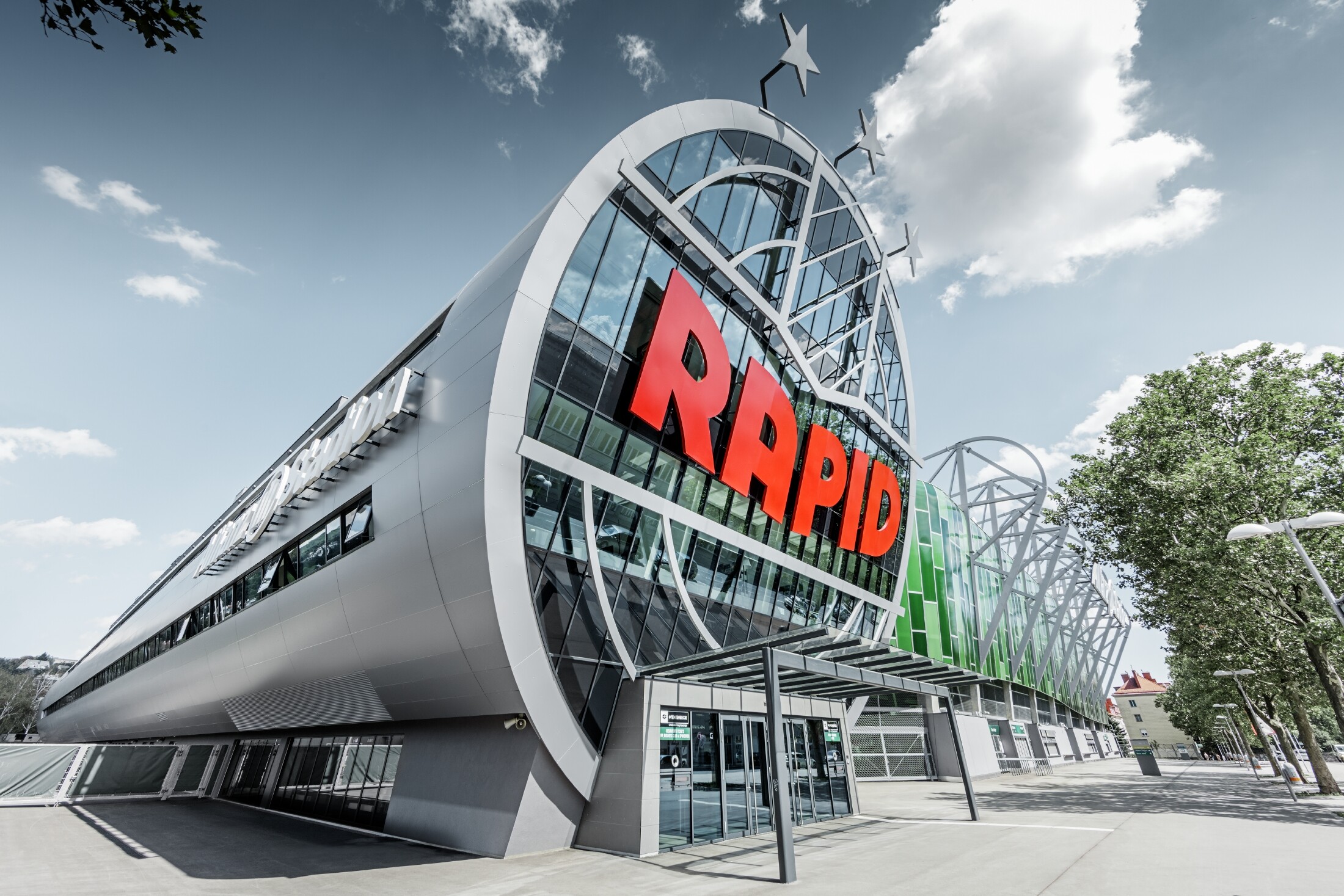 Der Eingang ins Allianz Stadion mit dem großen SK Rapid Wien Logo; Die Röhre mit der großen Glasfront ist mit der PREFA Aluminium Verbundplatte in Silbermetallic eingedeckt.