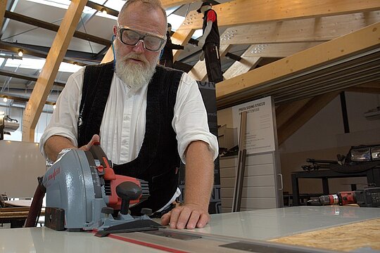 Tom Weiß hält die Unfallverhütungsvorschriften (UVV) ein und arbeitet mit Schutzbrille sowie Gehörschutz.