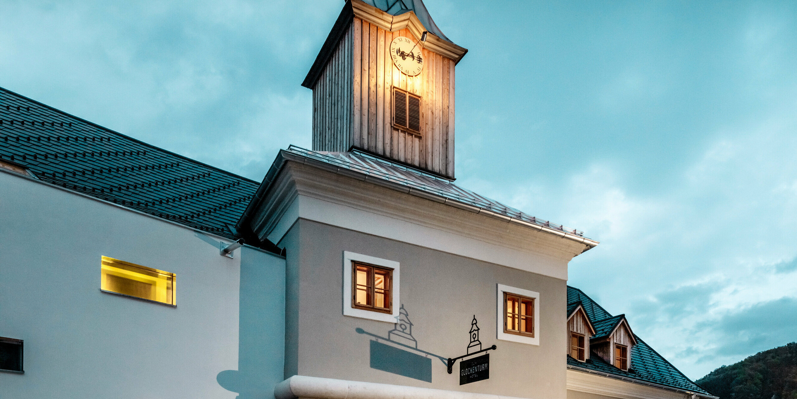 Das Dach des Hotels Glockenturm in Marktl bei Lilienfeld wurde mit der PREFA Dachschindel in P.10 Anthrazit verkleidet. Das PREFA Dachentwässerungssystem des Gebäudes ist in Naturblank gehalten. Unweit vom Hotel Glockenturm liegt das Leopold - unser Wirtshaus. Das Restaurantgebäude wurde ebenfalls mit PREFA Produkten eingedeckt.