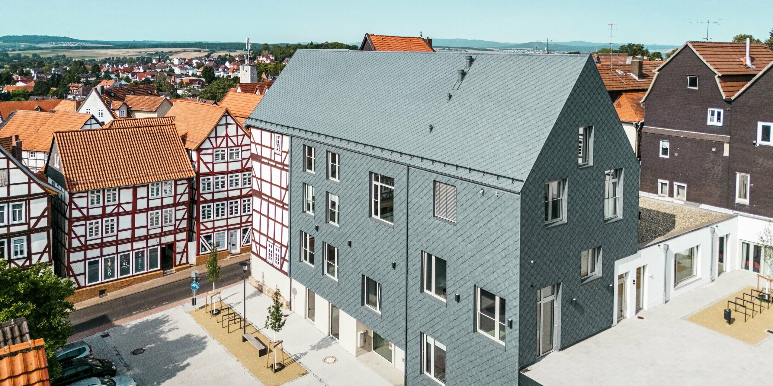 Hochwertige Sanierung des Volkshauses in Homberg, DE, eingebettet in die historische Altstadt mit Fachwerkhäusern. Dach, Giebel und große Teile der Fassade sind mit robusten und eleganten PREFA Aluminium-Rauten 29 × 29 in P.10 Steingrau eingedeckt. Die schuppenartige Aluminiumdeckung ist langlebig, farbbeständig und fügt sich perfekt in die geschichtsträchtige Umgebung ein.