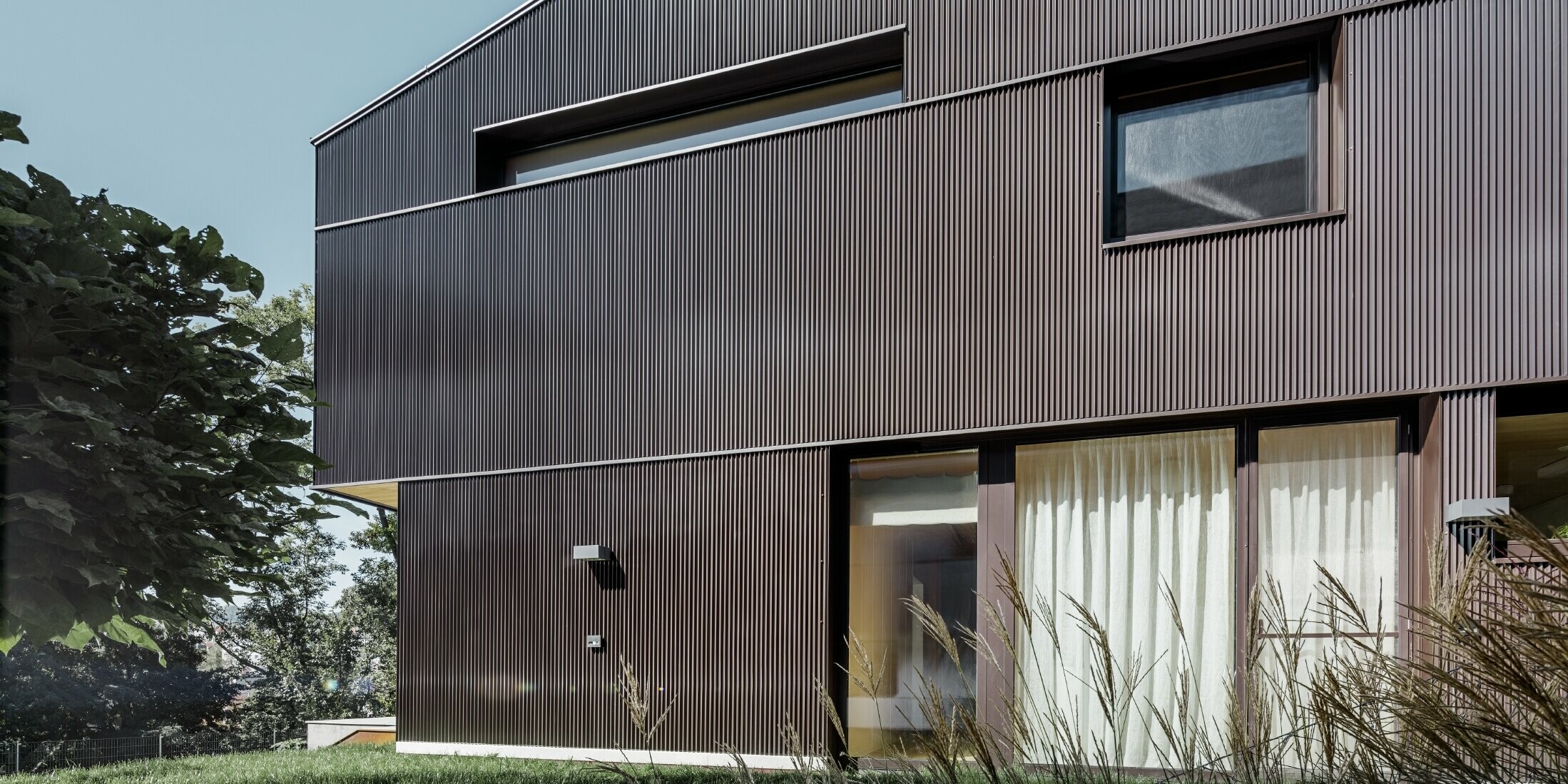 Modernes Einfamilienhaus mit einer Fassadenbekleidung von PREFA - Zackenprofil in Braun.