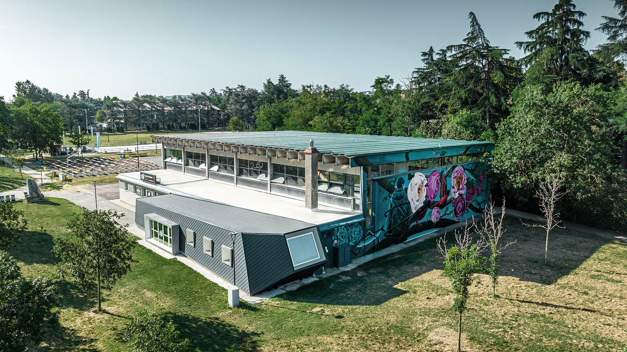 Die Turnhalle Rodriguez und ihr Zubau umgeben vom Parkgelände aus der Vogelperspektive.