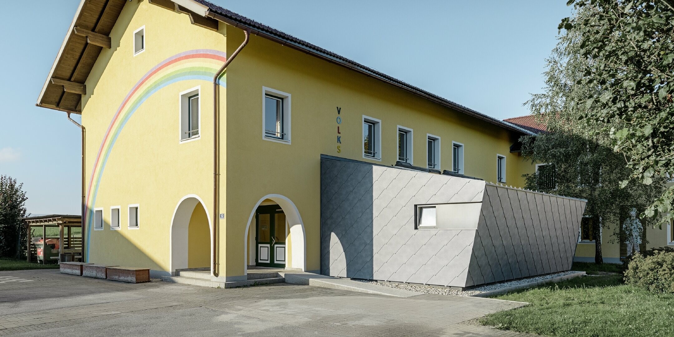 Zubau einer Volksschule eingedeckt mit der Dach- und Wandraute aus Aluminium von PREFA in steingrau