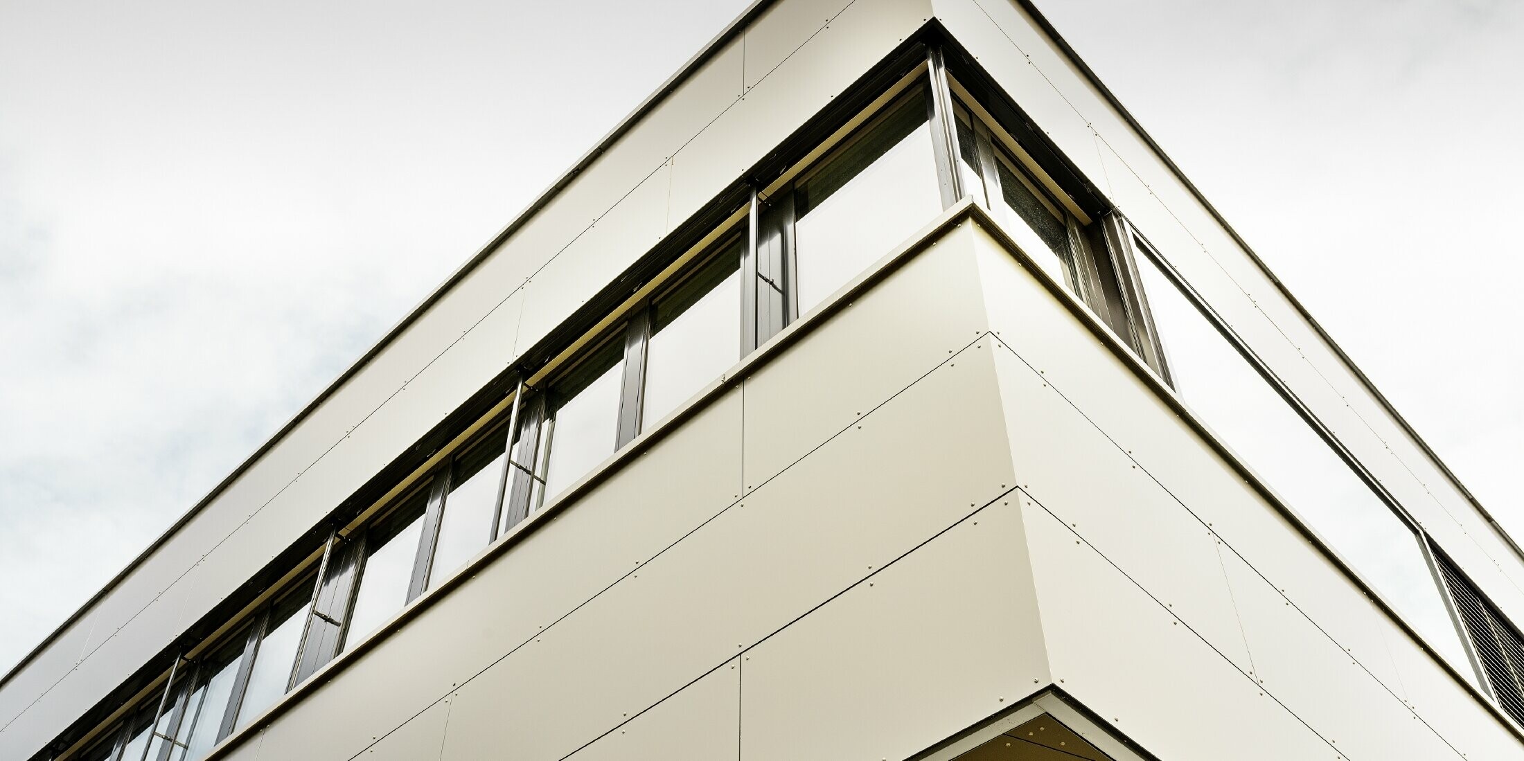 moderner Zubau mit Werkstatt und Büro von Guggisbau Dachtechnik mit der PREFA Aluminium Verbundplatte in bronze